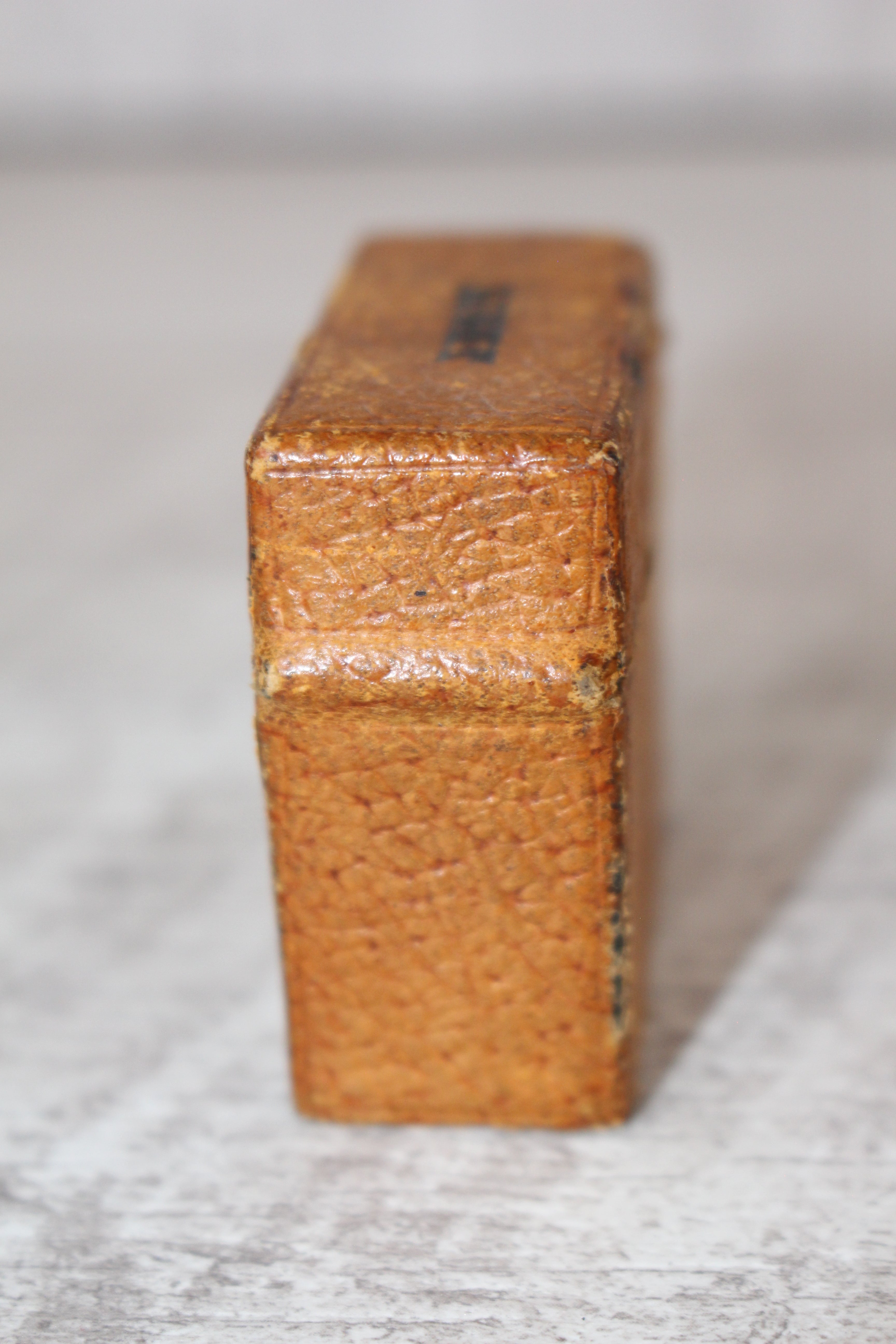Edwardian metal leatherette covered vesta case, original matches