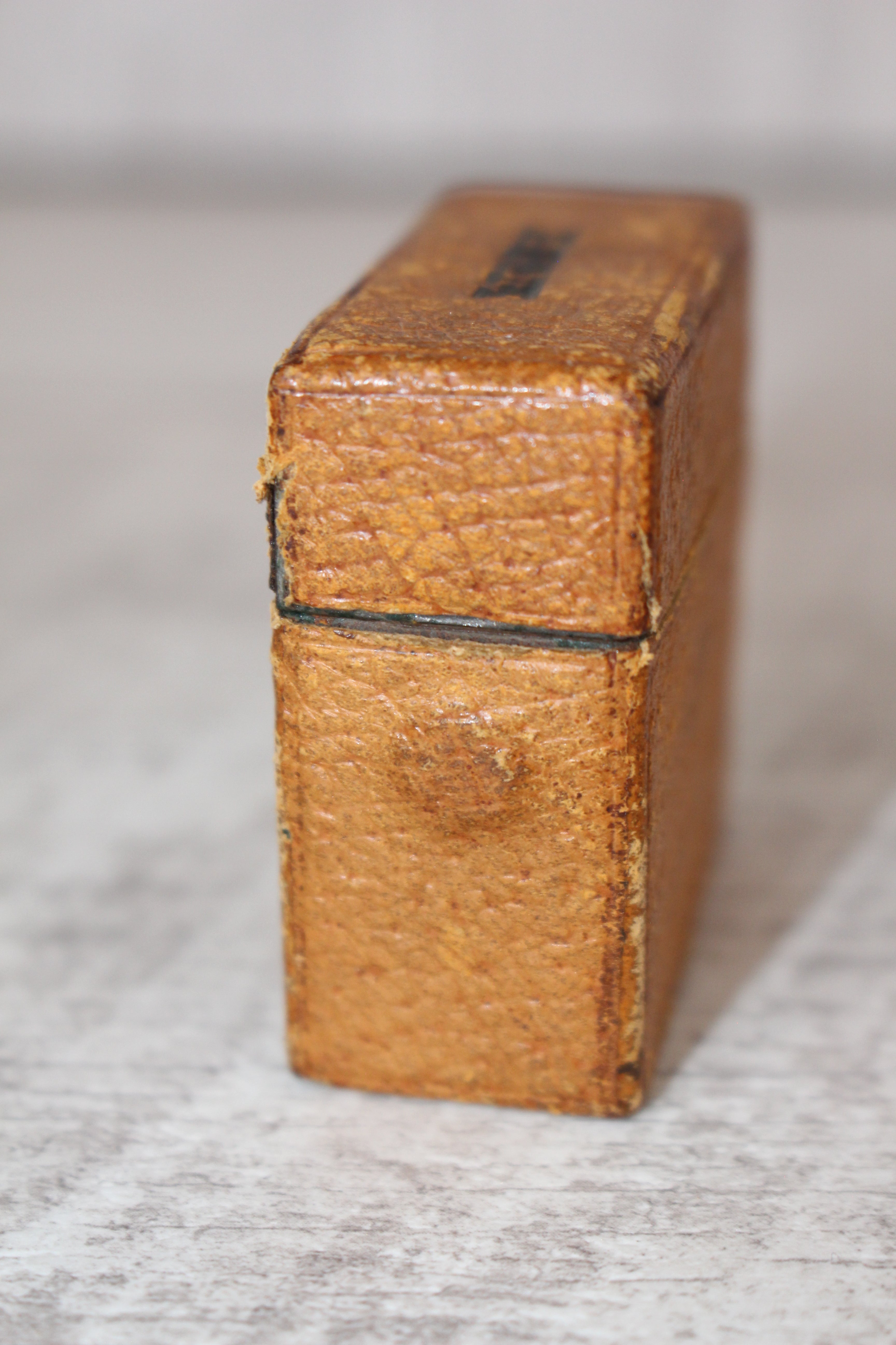 Edwardian metal leatherette covered vesta case, original matches